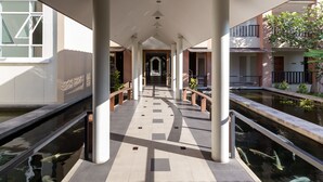 A corridor with a central walkway flanked by water features and columns. - Authong Residence Pattaya (Pattaya)