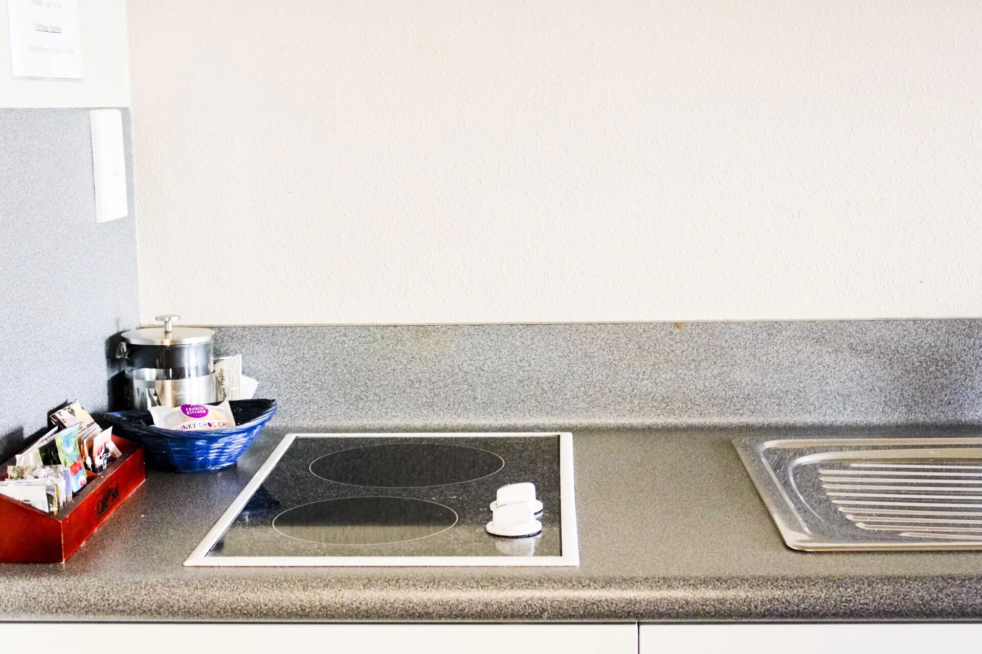 A kitchen with a stove, a sink, and a coffee maker.
