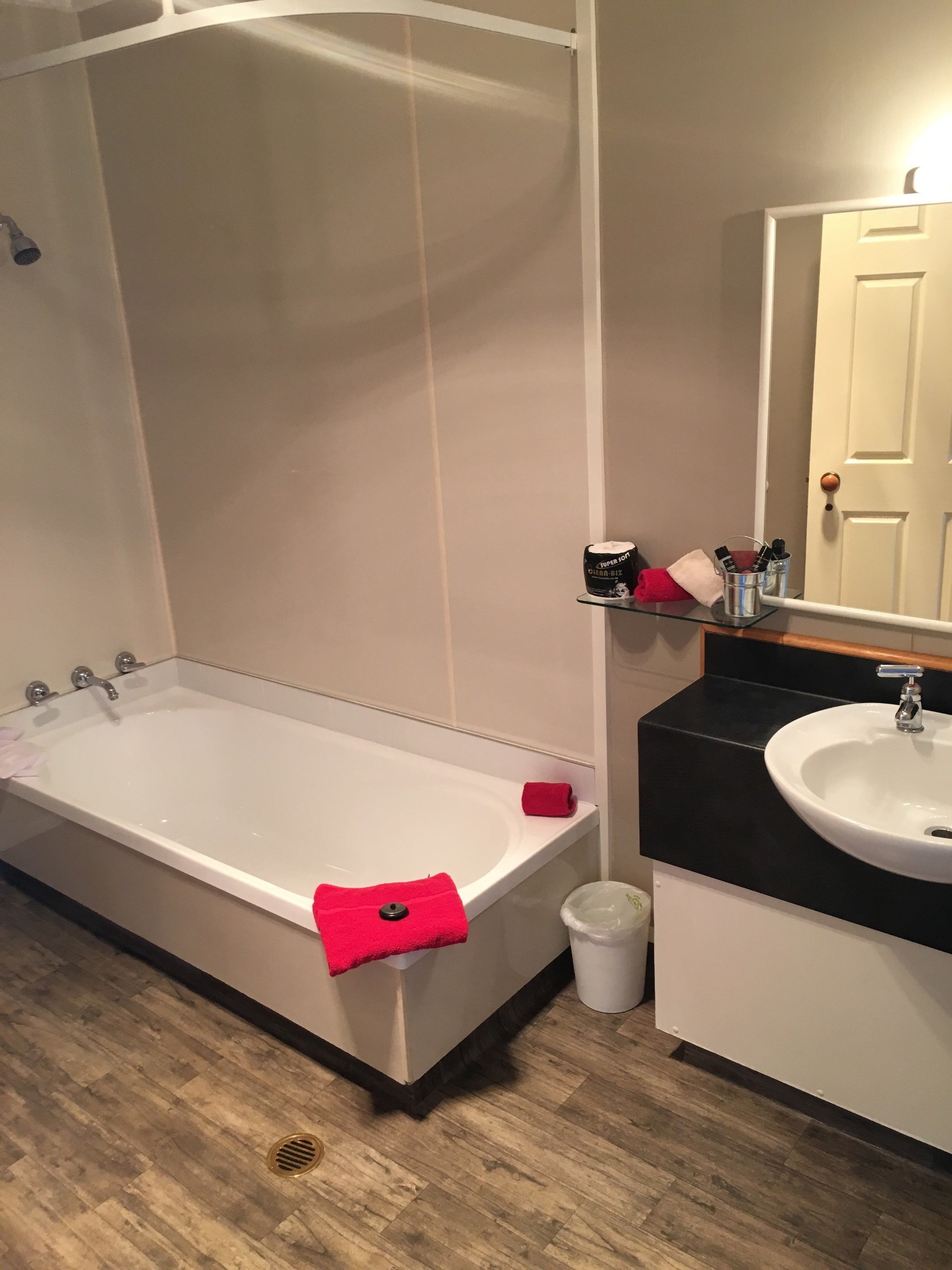 A bathroom with a bathtub, a sink, and a mirror.