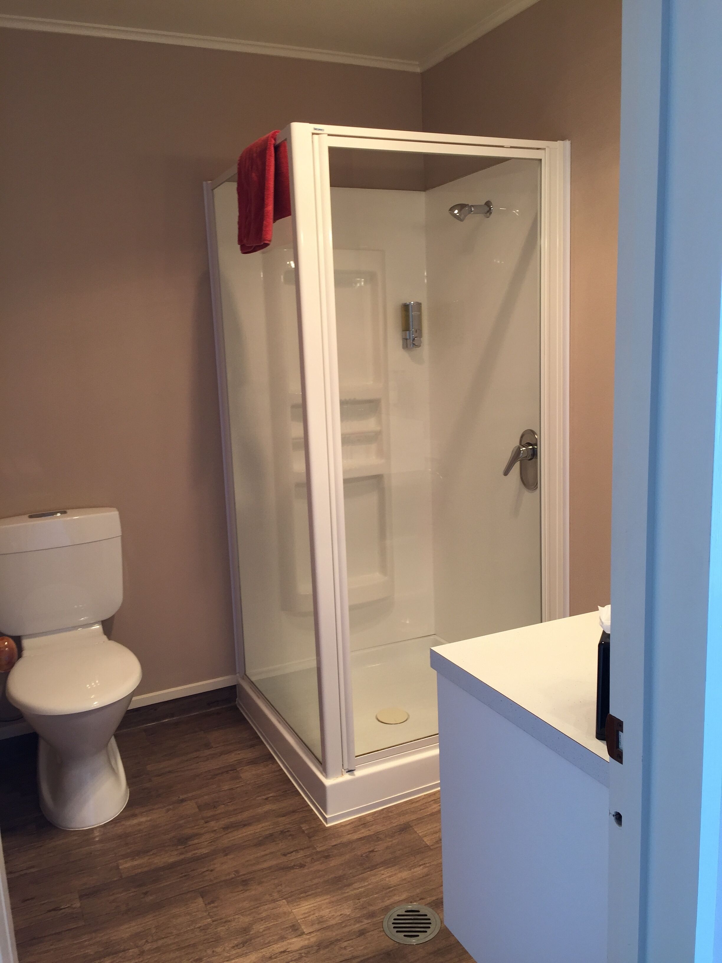 A bathroom with a toilet, a shower enclosure, and a sink.