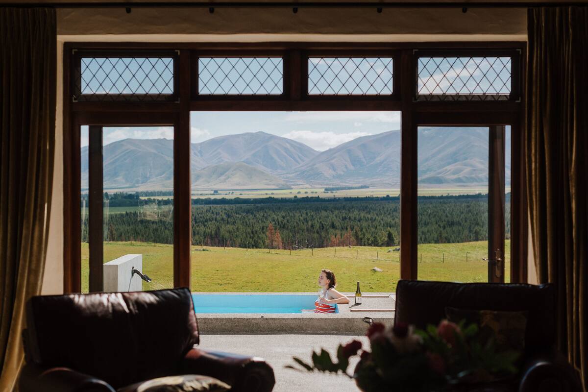 A room with a large window overlooking a mountainous landscape.