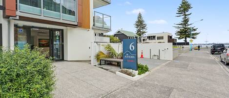 A modern building with a wheelchair-accessible entrance, a sign indicating a vacancy, and a number 6 sign.