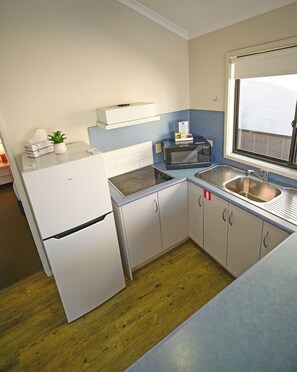 A compact kitchen with a refrigerator, microwave, toaster, and sink. - Apollo Bay Waterfront Motor Inn (Apollo Bay)