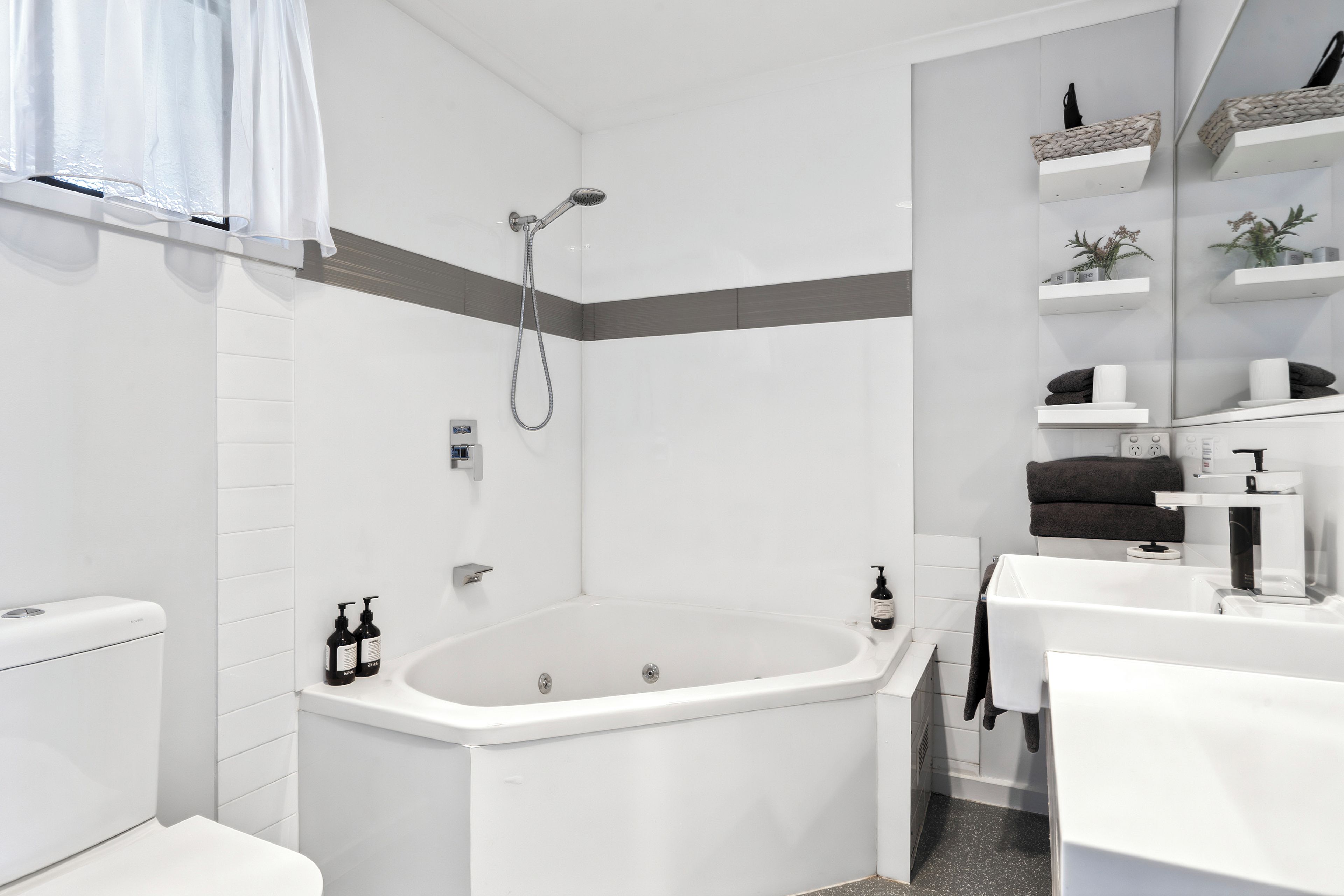 A modern bathroom with a freestanding bathtub, a toilet, and a shower.