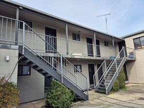 A multi-story building with external staircases, balconies, and a visible antenna. - Apollo Bay Waterfront Motor Inn (Apollo Bay)