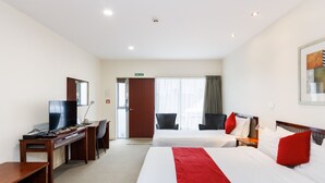 A hotel room with two beds, a desk with a TV, and a chair. - Fitzherbert Regency Motor Lodge (Palmerston North)
