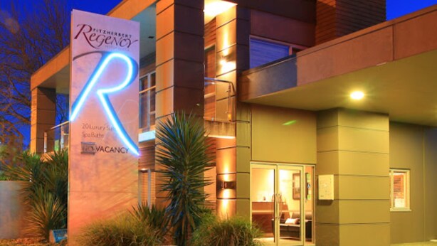 A modern building with a prominent illuminated 'R' sign, indicating a hotel or resort. - Fitzherbert Regency Motor Lodge (Palmerston North)