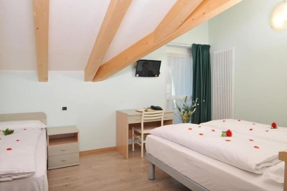 A bedroom with two beds, a desk, and a chair.