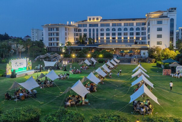 A hotel with multiple tents set up on the lawn, a stage with a banner, and a large building in the background. - Xiamen C&D Hotel (Xiamen)