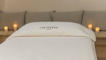 A bed with a white pillow labeled "SOTHYS PARIS" and a beige headboard.