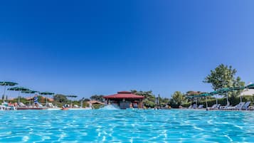 Una piscina al aire libre de temporada, sombrillas