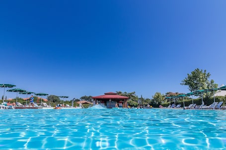 Una piscina al aire libre de temporada, sombrillas