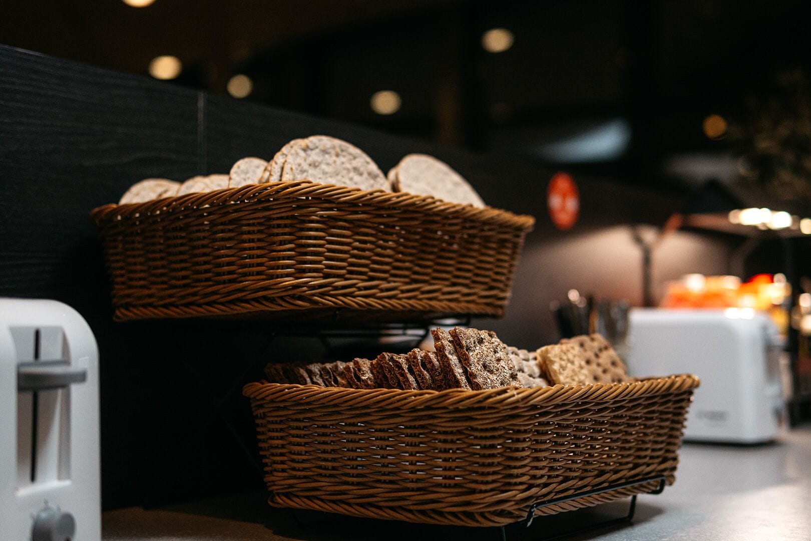 Two wicker baskets filled with sliced bread on a counter.