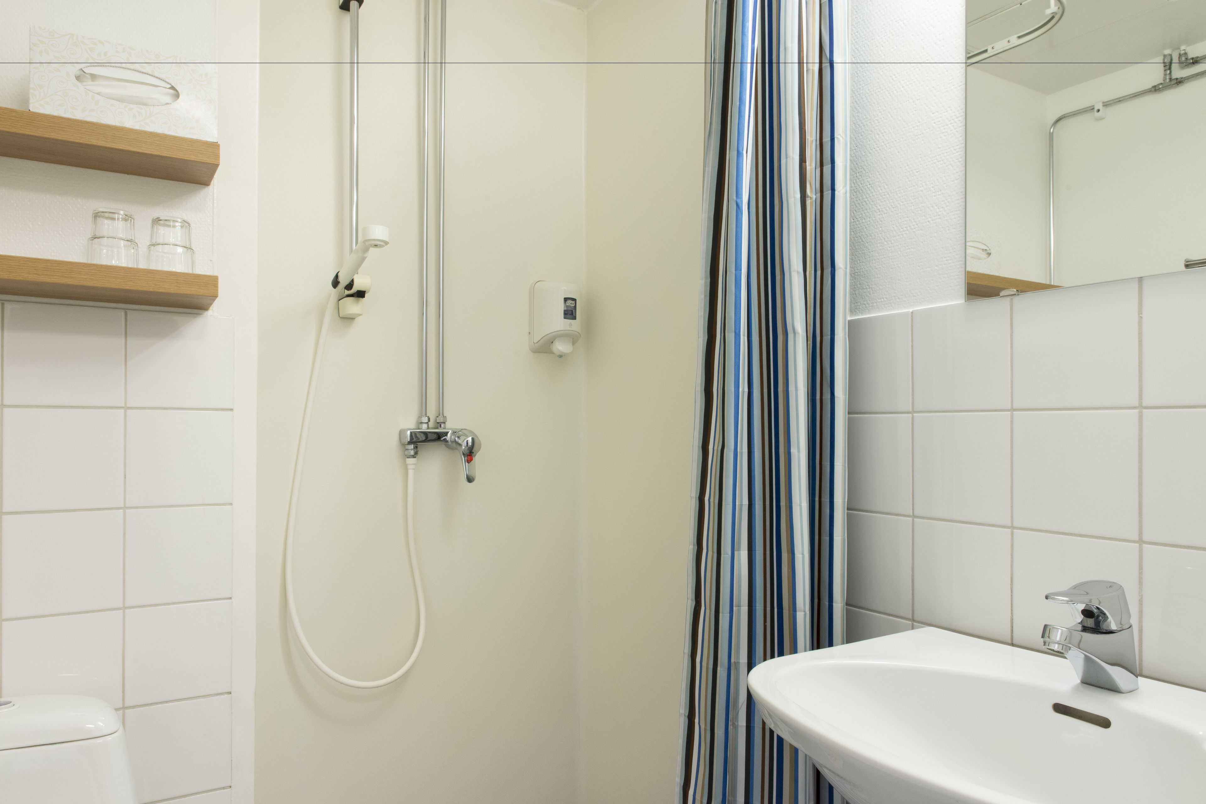 A bathroom with a shower, toilet, and sink.