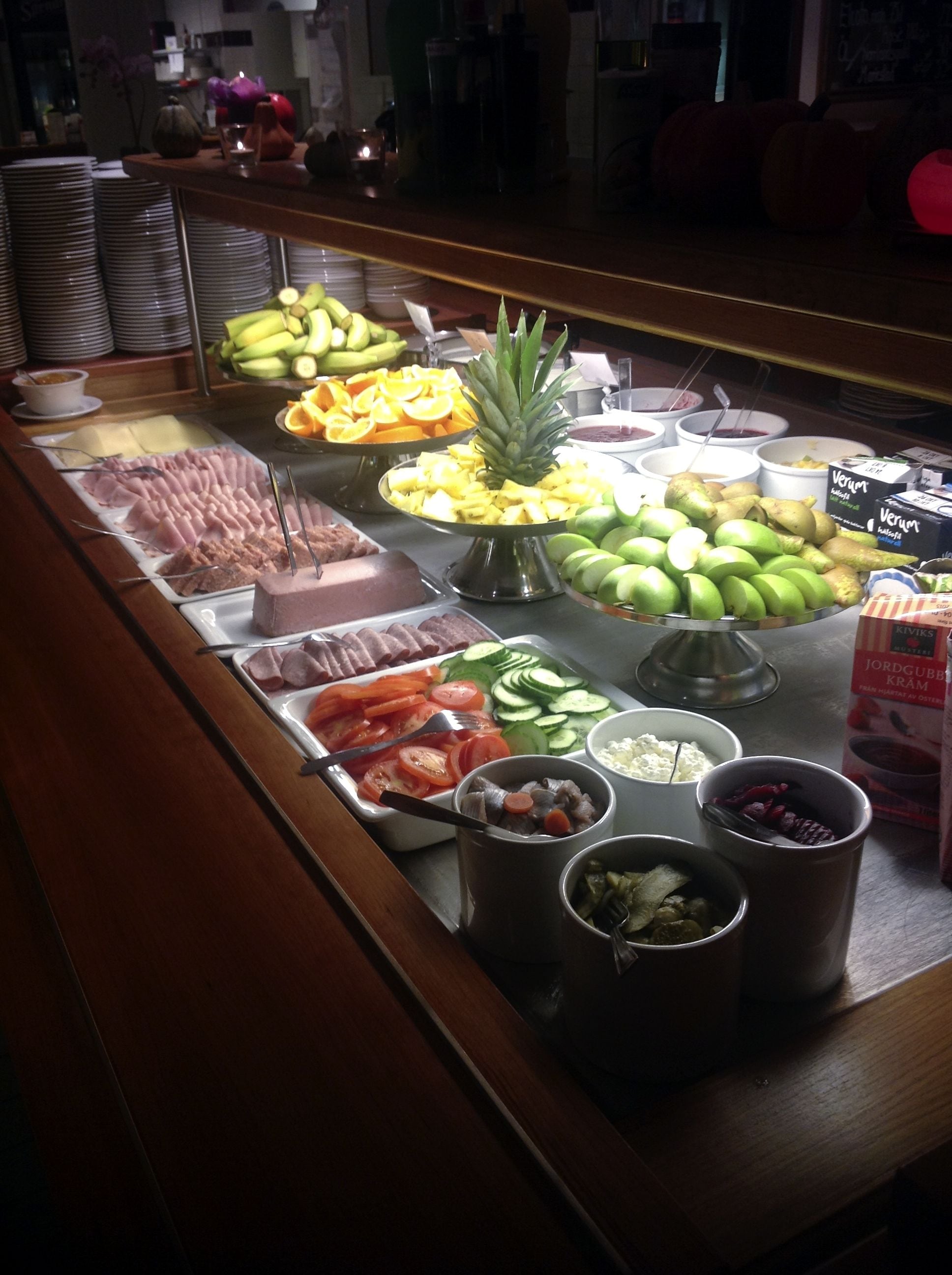 A buffet with various food items including fruits, vegetables, and meats.