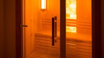 Uma sauna com bancos de madeira e porta de vidro.