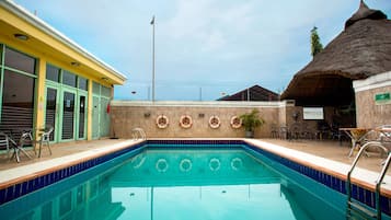 Een buitenzwembad, parasols voor strand/zwembad