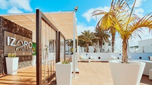 An outdoor area with a reception desk, seating, and potted plants. - Gloria Izaro Club Hotel (Tías)