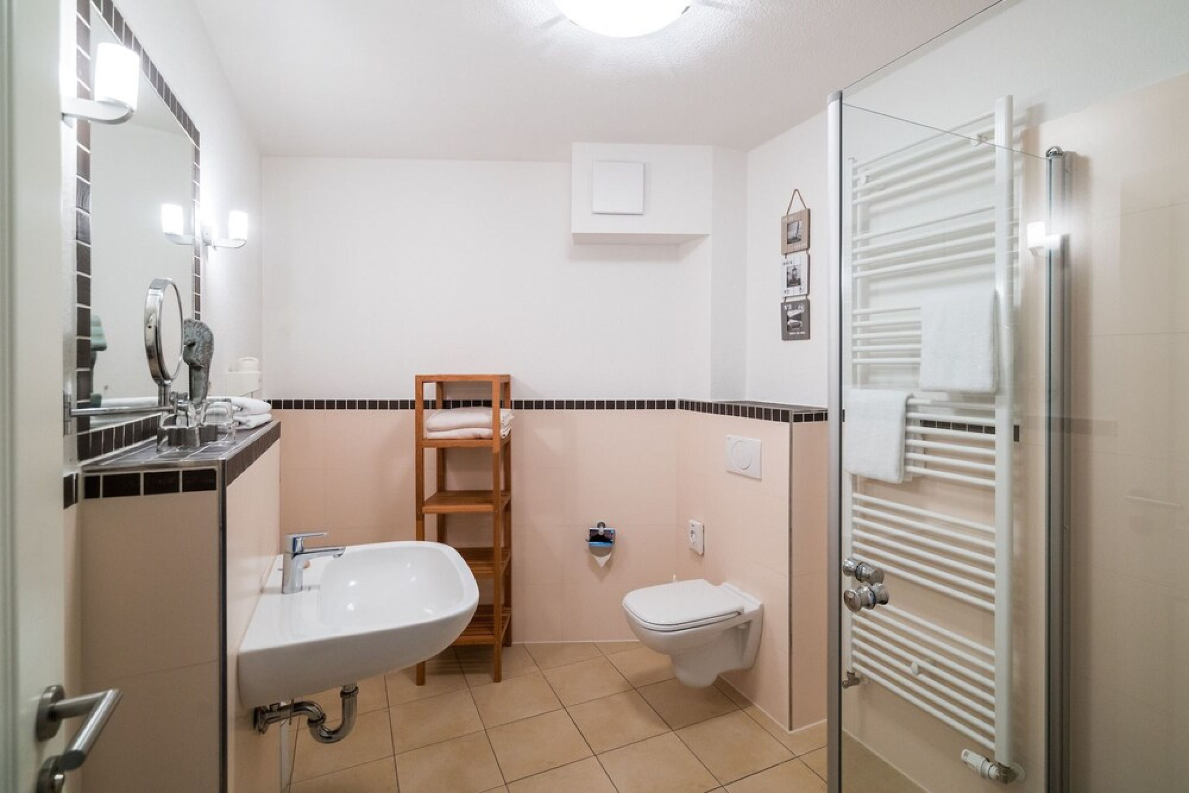 Un bagno con lavandino, WC e cabina doccia in vetro.