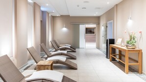 A spa area with wicker loungers, a wooden table, and a TV on a stand.