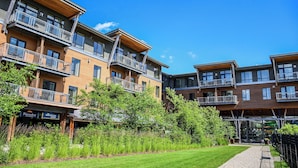 A multi-story hotel with balconies, a grassy courtyard, and a storefront named 'Foundry Mountain Shop'. - Jay Peak Resort (North Troy)