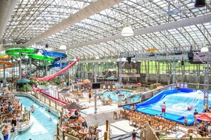 An indoor water park with slides, pools, and seating areas. - Jay Peak Resort (North Troy)