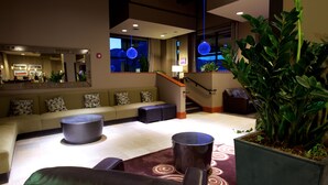 A modern lobby with a sofa, coffee table, and potted plant. - Jay Peak Resort (North Troy)