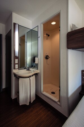 A bathroom with a sink, mirror, and shower. - Hotel Hi (Zapopan)