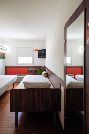 A hotel room with two single beds, a wooden headboard, a flat-screen TV, and a window with blinds. - Hotel Hi (Zapopan)