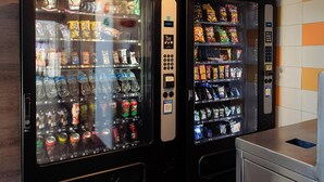 Two vending machines in a room with tiled flooring and a metal cabinet. - Hotel Hi! Zapopan (Zapopan)