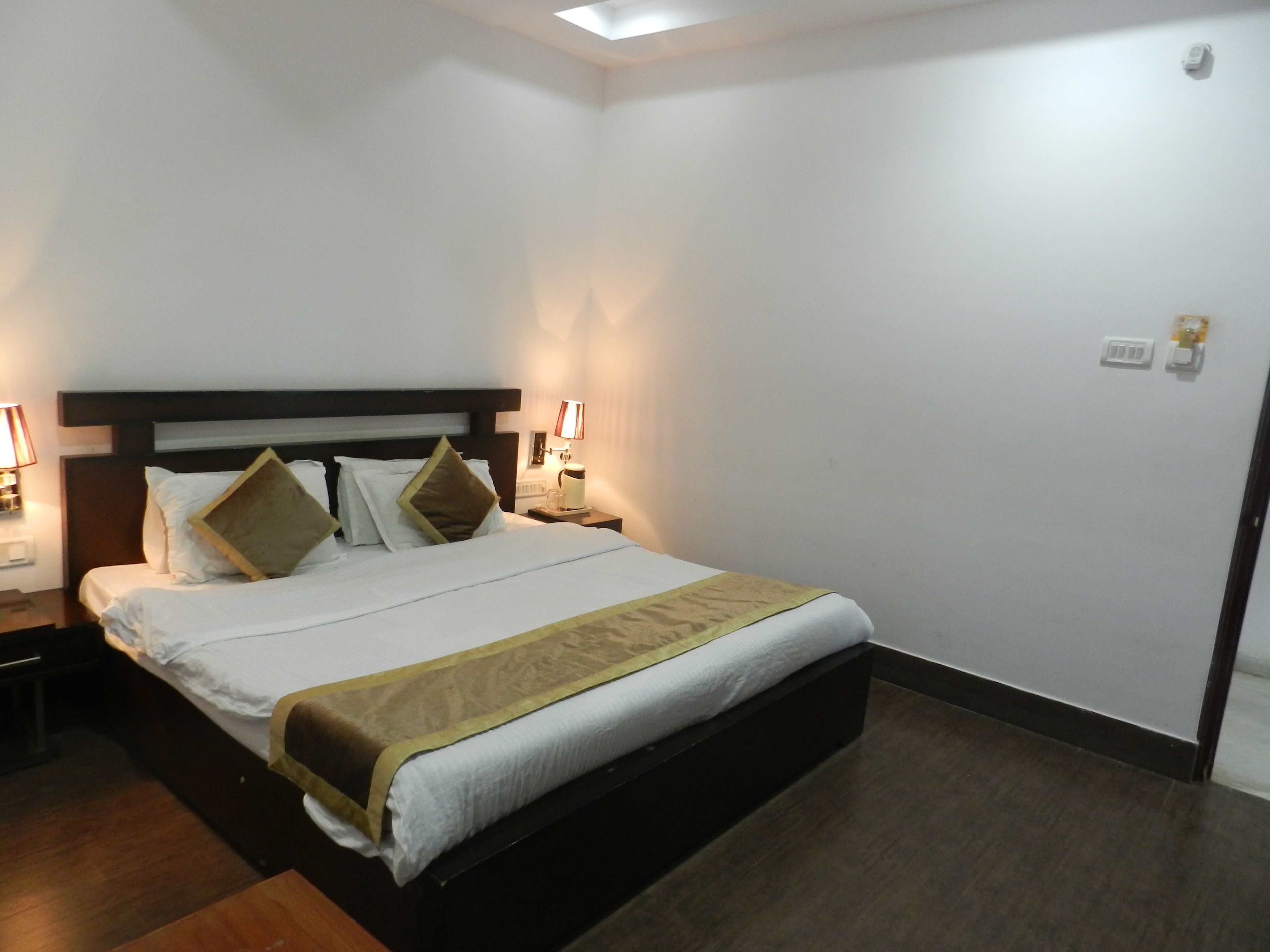 Una camera d'albergo con un letto, comodini e una lampada a parete.