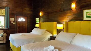 A hotel room with two beds, wooden walls, and a window with curtains.