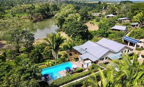 A resort with a swimming pool, solar panels, and lush greenery. - Dream Valley Belize (Belmopan)