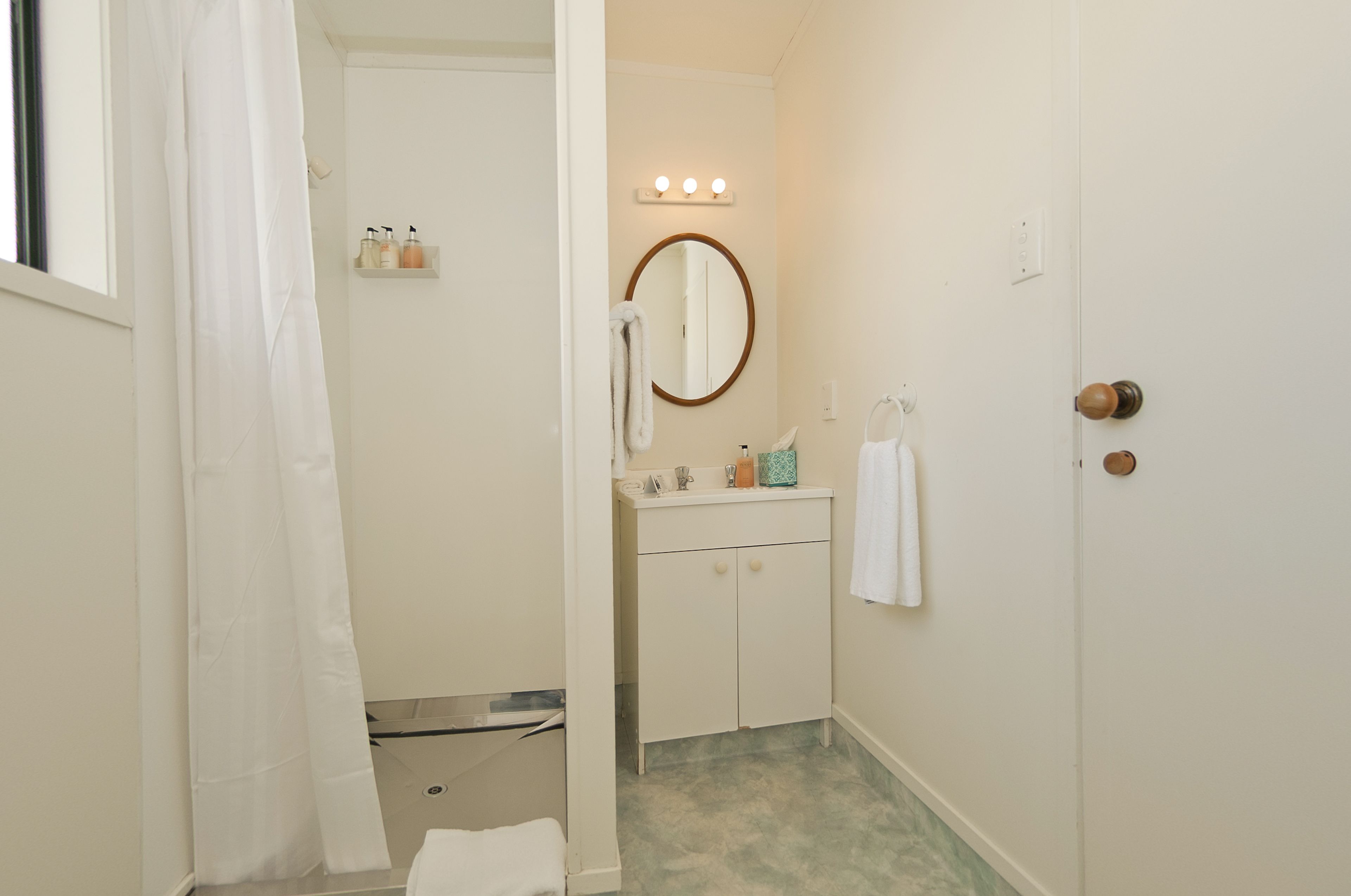 A bathroom with a sink, mirror, and vanity.