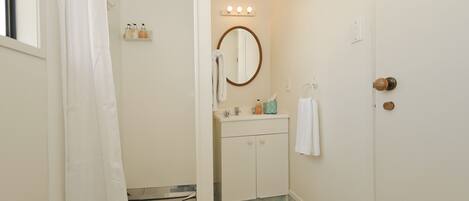A bathroom with a sink, mirror, and vanity.