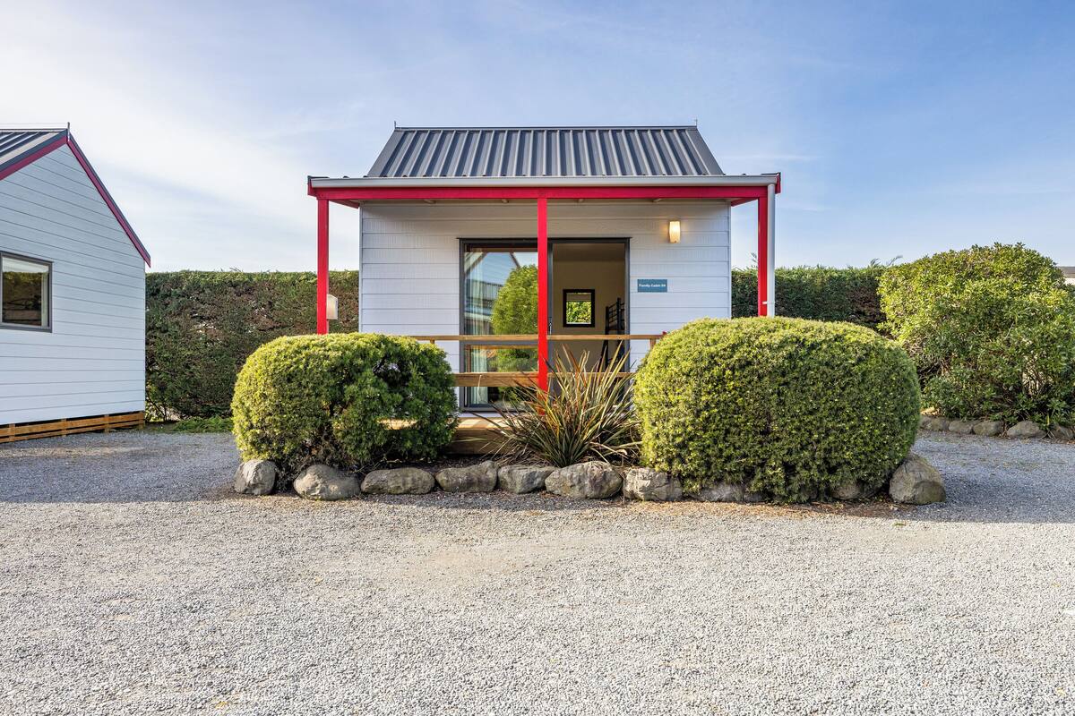 Un petit bâtiment d’un seul étage, à l’extérieur rouge et blanc, doté d’un porche couvert et d’une allée en gravier.