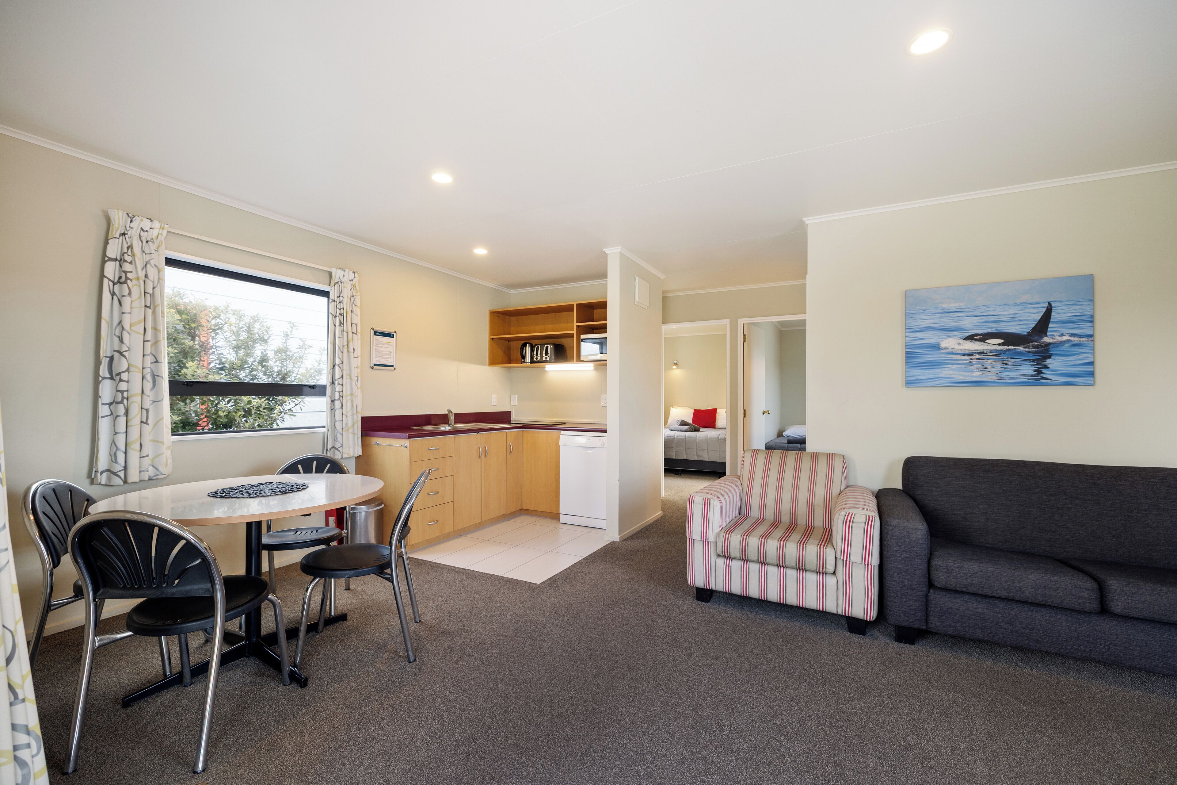 A compact living space with a dining area, kitchenette, and a sofa.