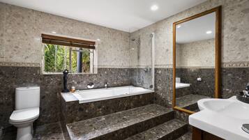 Une salle de bain moderne avec une baignoire, des toilettes et un lavabo.