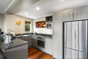 Suite Deluxe | Cuisine privée | Réfrigérateur, four à micro-ondes, un four, surface de cuisson