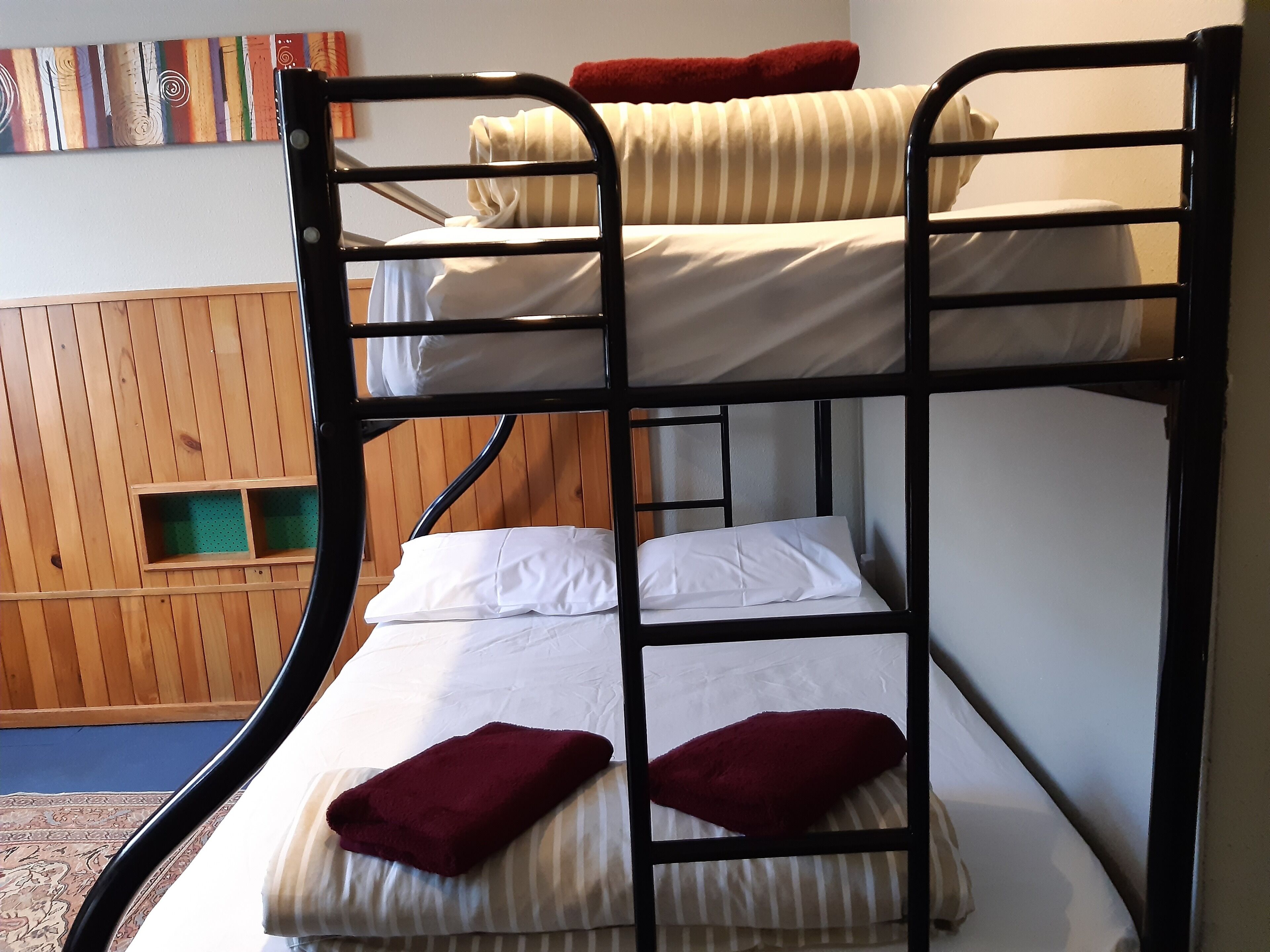 A bunk bed with two levels, each with pillows and a blanket.