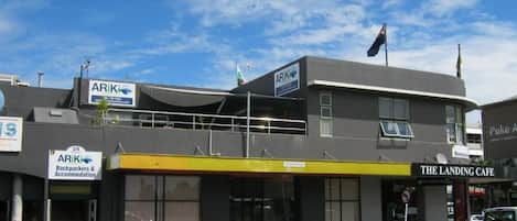 A building with signs for 'ARIK Backpackers & Accommodation' and 'The Landing Cafe'.
