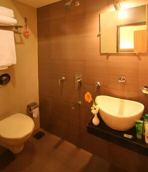 Un baño con inodoro, lavamanos y ducha.
