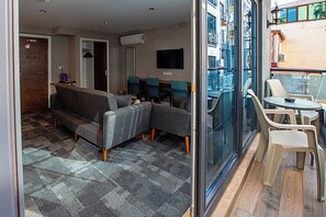 A modern living room with a sofa, chairs, a coffee table, and a glass partition. - Aston Hotel Taksim (Istanbul)