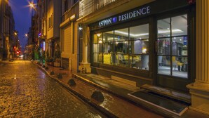 A nighttime street view of a building with a storefront labeled "ASTON RESIDENCE." - Aston Hotel Taksim (Istanbul)