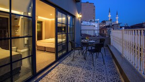 A balcony with a bed, chairs, and a table. - Aston Hotel Taksim (Istanbul)