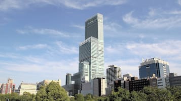A high-rise building with a modern glass facade, surrounded by other buildings and trees.