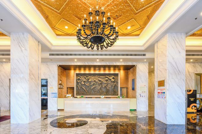 A lobby with a marble floor, a chandelier, and a reception desk.