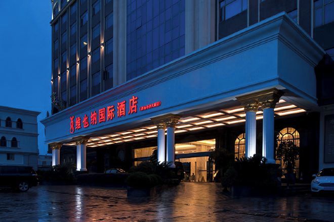A hotel entrance with a covered area, columns, and a sign with Chinese characters.