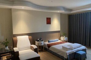 A hotel room with a bed, a chair, a nightstand, and a small table. - Vienna International Hotel (Shantou Chenghai Waisha Bridge) (Shantou)