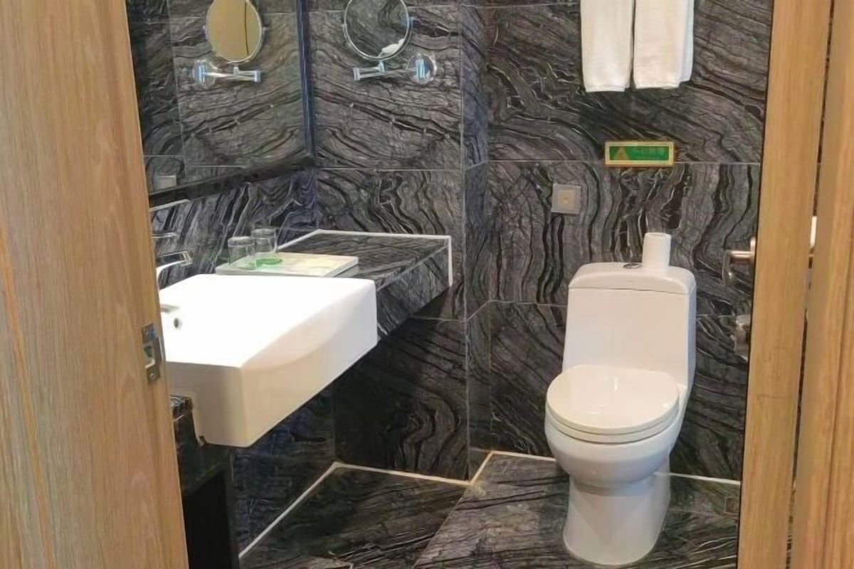 A bathroom with a white sink, a toilet, and a mirror.